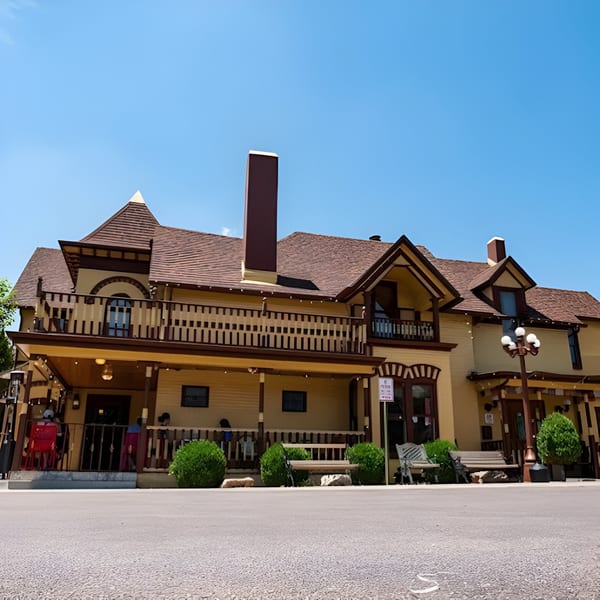 Yak and Yeti restaurant, a large yellow building with brown trim, balconies, and a patio under a clear sky.